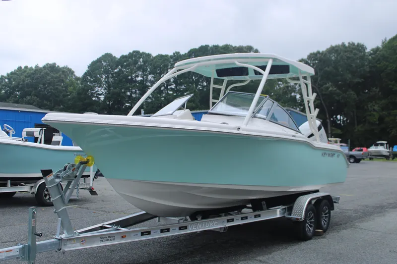 Slide: The Image of 2026 Key West 239 DFS boat on trailer, light blue hull, parked outdoors. - 1
