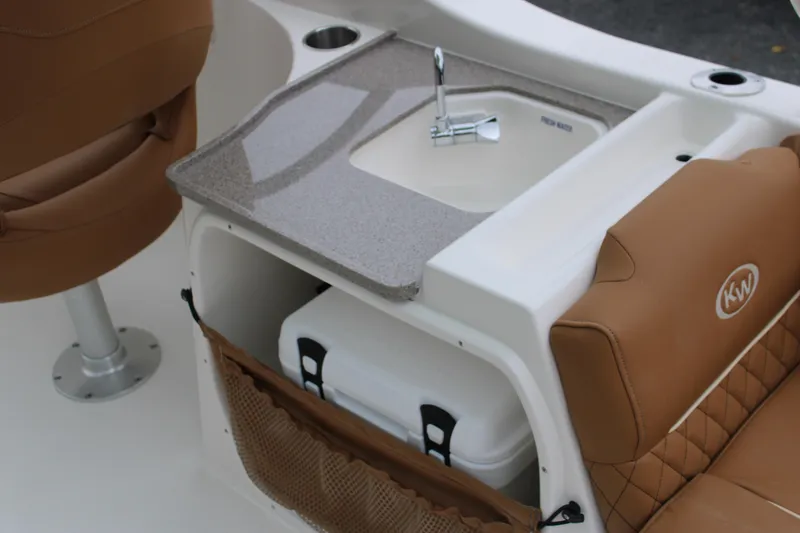 Slide: The Image of 2026 Key West 239 DFS boat interior with sink, storage, and tan seating. - 18