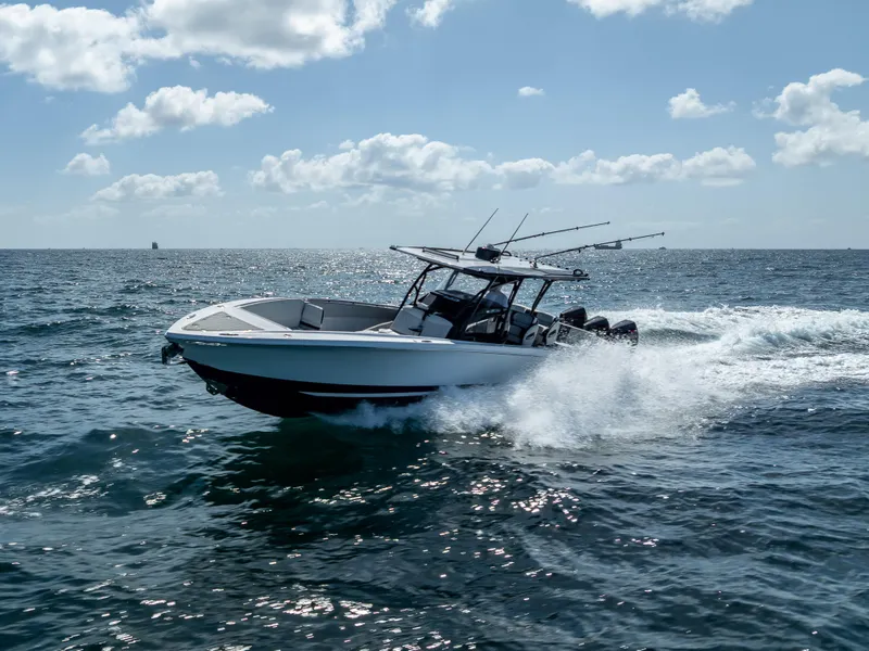 The Image of 2022 Nor-Tech 390 Sport Center Console cruising on open water under a cloudy sky. - 0