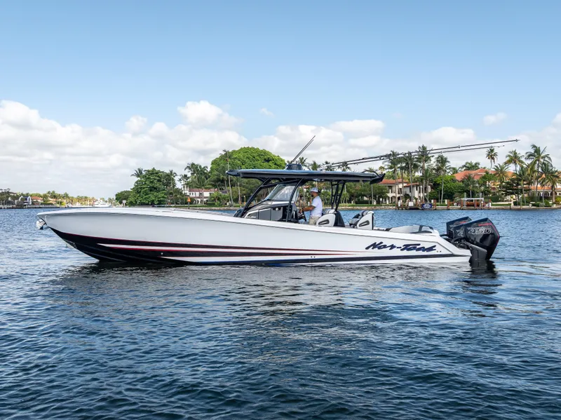 Slide: The Image of 2022 Nor-Tech 390 Sport Center Console boat on calm water, with scenic background. - 1