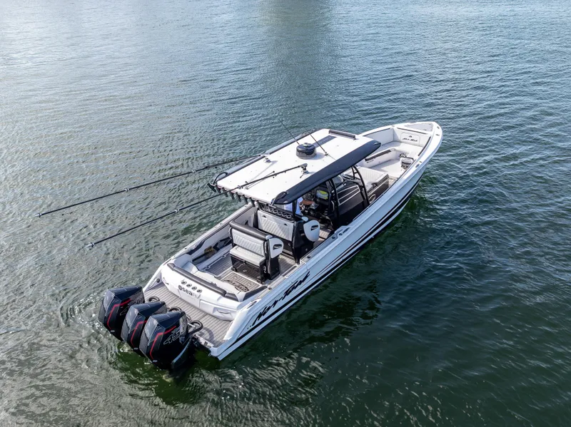 Slide: The Image of 2022 Nor-Tech 390 Sport Center Console boat on water, featuring triple outboard engines. - 10