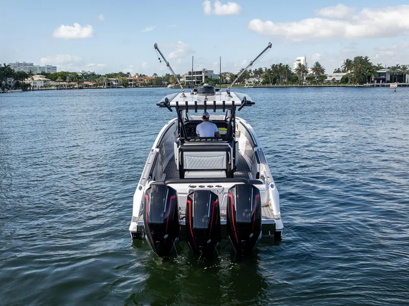 Slide: The Image of 2022 Nor-Tech 390 Sport Center Console boat on calm water, rear view. - 11