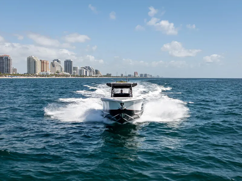 Slide: The Image of 2022 Nor-Tech 390 Sport Center Console cruising on ocean near city skyline. - 14