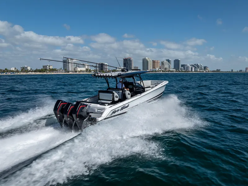 Slide: The Image of 2022 Nor-Tech 390 Sport Center Console speeding on ocean near city skyline. - 19