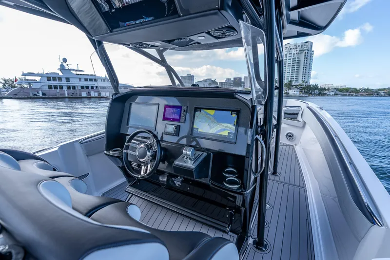 Slide: The Image of 2022 Nor-Tech 390 Sport Center Console boat interior with navigation screens and steering wheel. - 23