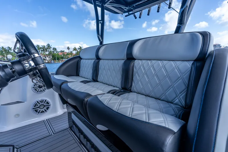 Slide: The Image of 2022 Nor-Tech 390 Sport Center Console boat with luxurious seating and steering wheel. - 26