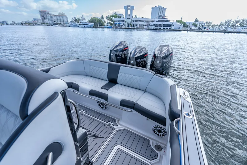 Slide: The Image of 2022 Nor-Tech 390 Sport Center Console with triple engines, luxurious seating, and waterfront view. - 32