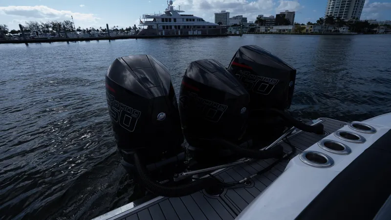 Slide: The Image of 2022 Nor-Tech 390 Sport Center Console with triple outboard engines on water. - 36