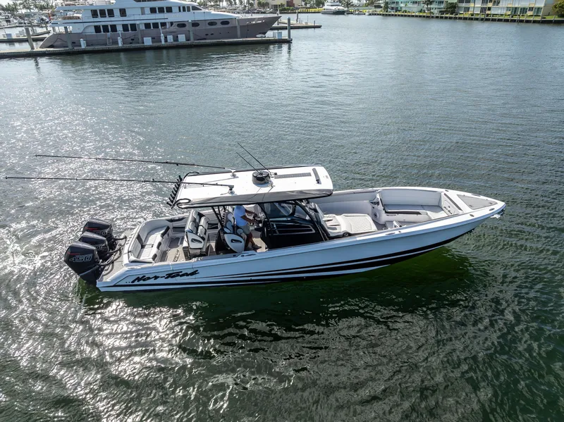 Slide: The Image of 2022 Nor-Tech 390 Sport Center Console boat on water, featuring sleek design and powerful engines. - 4