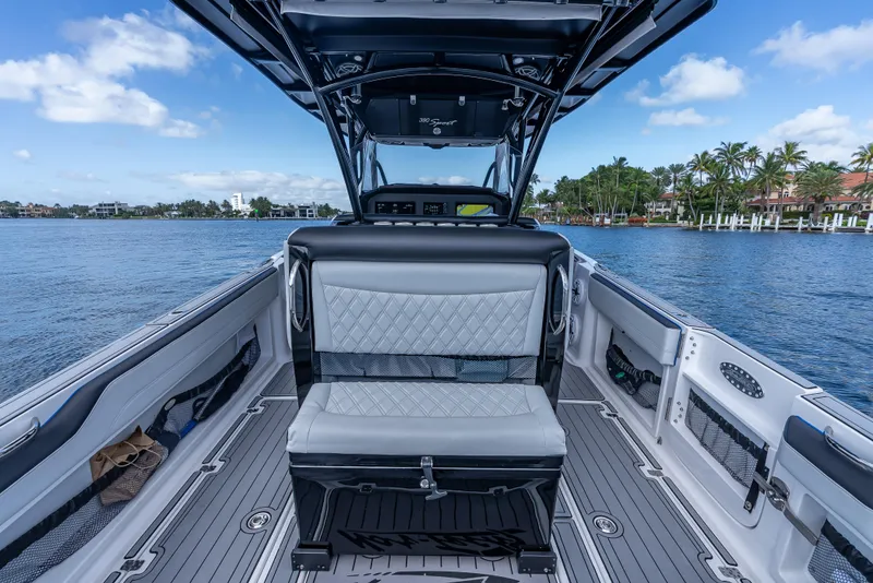 Slide: The Image of 2022 Nor-Tech 390 Sport Center Console boat interior with luxurious seating on a calm waterway. - 41