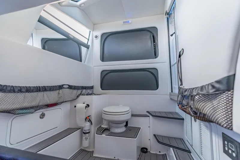 Slide: The Image of Interior of 2022 Nor-Tech 390 Sport Center Console boat, featuring a compact bathroom. - 49