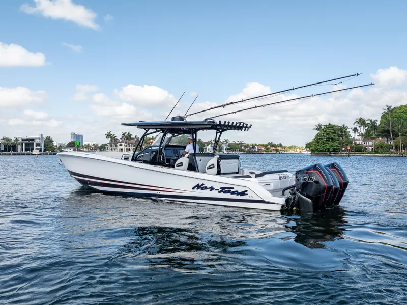 Slide: The Image of 2022 Nor-Tech 390 Sport Center Console boat on calm water, clear sky background. - 8