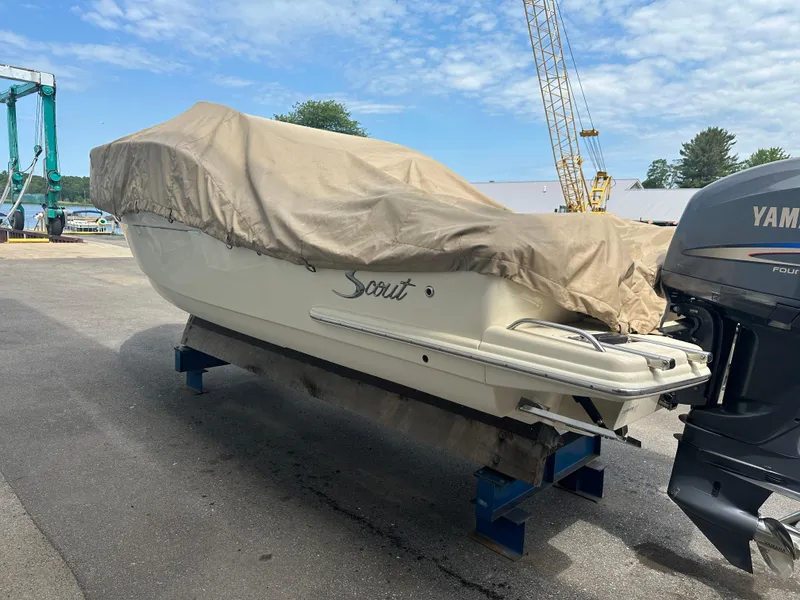 Slide: The Image of 2008 Scout 222 Abaco boat covered, with Yamaha outboard motor, on a dock. - 11