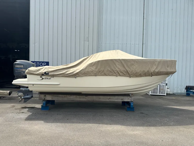 Slide: The Image of 2008 Scout 222 Abaco boat covered, with Yamaha outboard, parked on a stand. - 2