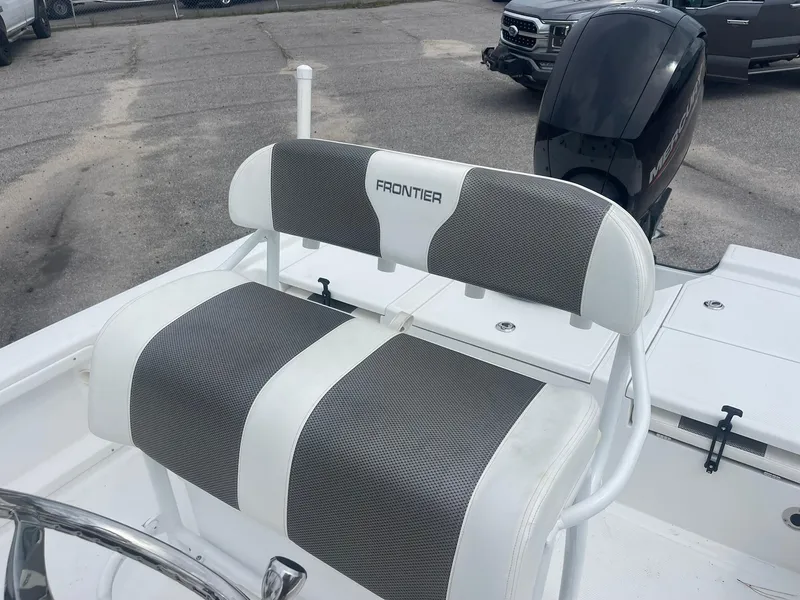 Slide: The Image of 2023 Frontier 2104 boat seat with gray and white upholstery, featuring a Mercury engine. - 10