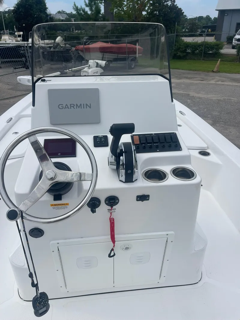 Slide: The Image of 2023 Frontier 2104 boat console with Garmin navigation, steering wheel, and control panel. - 13