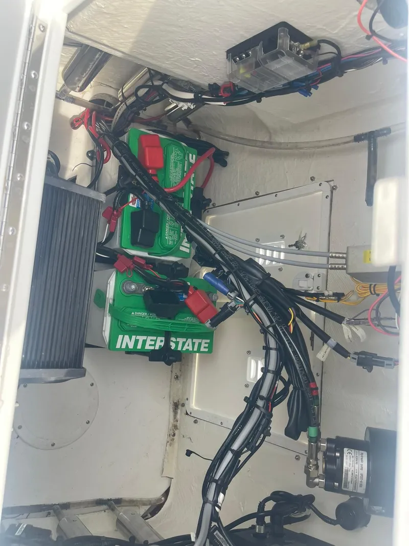 Slide: The Image of Electrical wiring and Interstate batteries inside a 2023 Frontier 2104 boat compartment. - 14