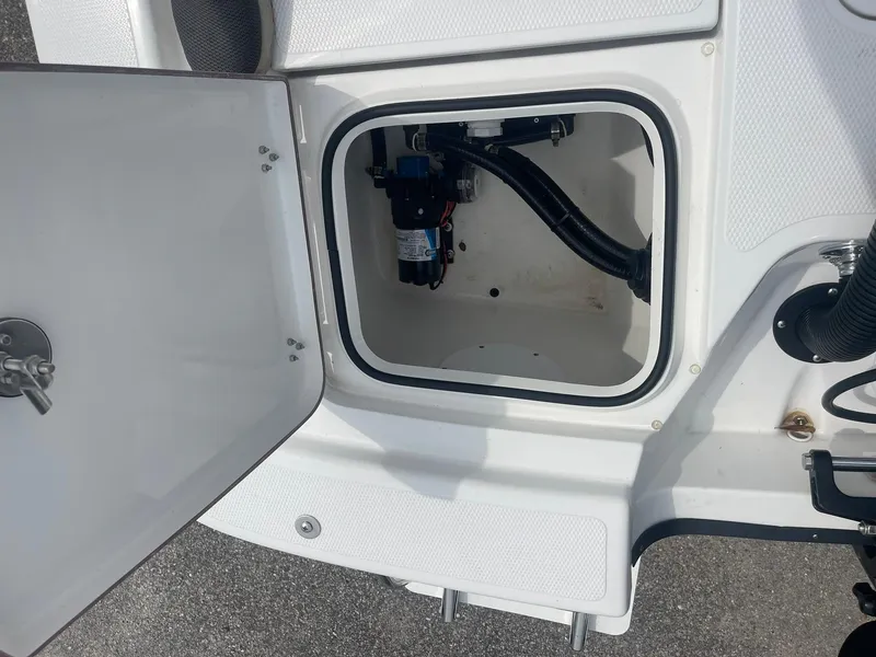 Slide: The Image of Open storage compartment on a 2023 Frontier 2104 boat, showing internal components and wiring. - 15