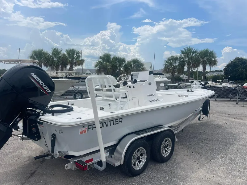 Slide: The Image of 2023 Frontier 2104 boat with Mercury engine on trailer, parked near palm trees. - 3