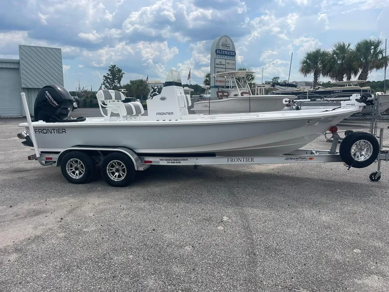 Slide: The Image of 2023 Frontier 2104 boat on trailer, parked outdoors under cloudy sky. - 4