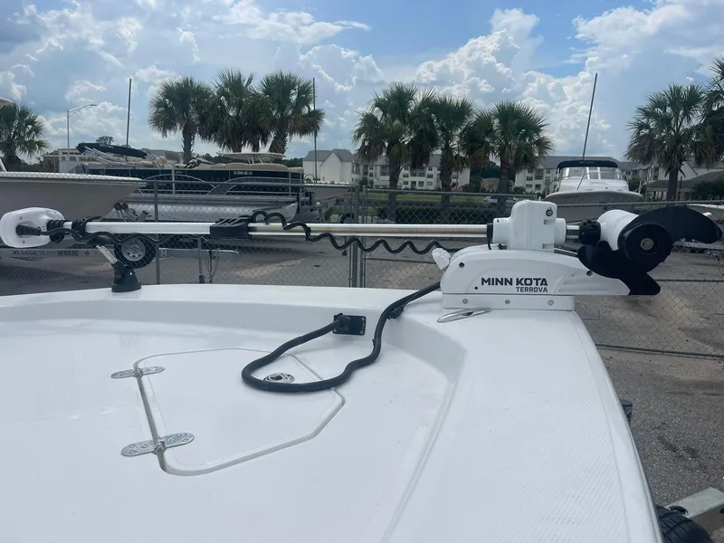 Slide: The Image of 2023 Frontier 2104 boat with Minn Kota Terrova trolling motor, docked near palm trees. - 5