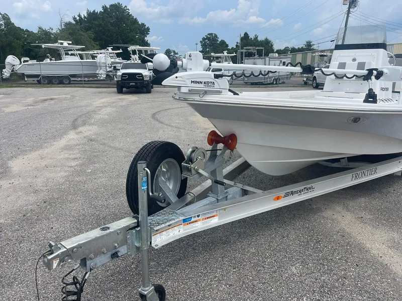 Slide: The Image of 2023 Frontier 2104 boat on trailer, parked in a lot with other boats. - 6