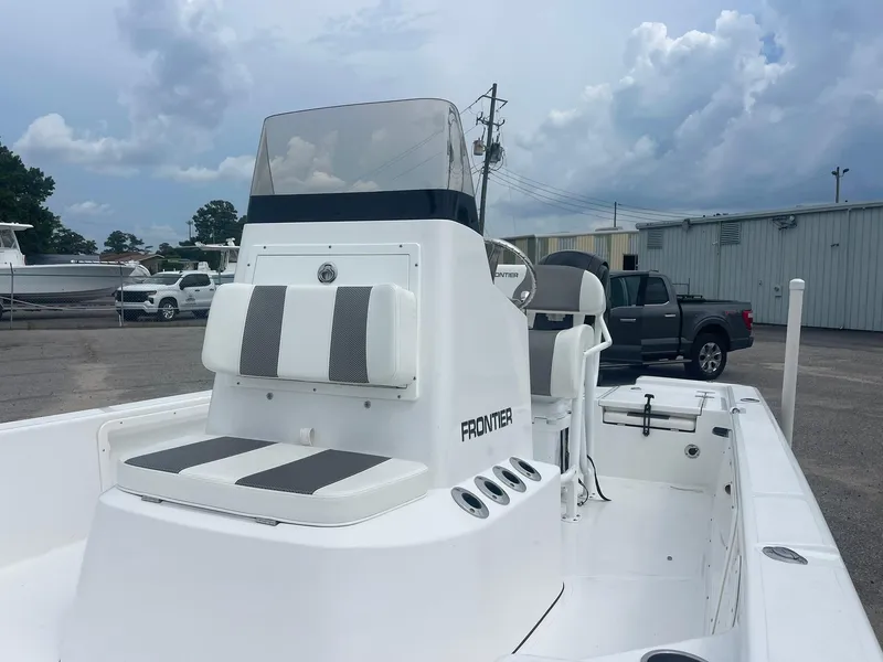 Slide: The Image of 2023 Frontier 2104 boat with seating, parked outdoors under cloudy sky. - 8