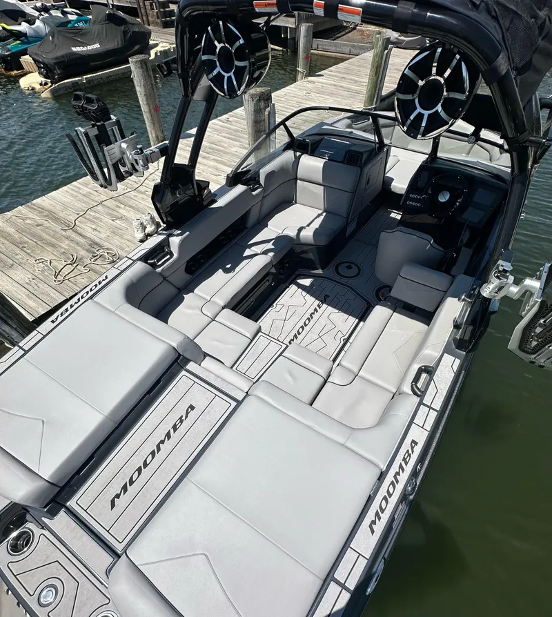 Slide: The Image of 2024 Moomba Kaiyen boat interior with sleek seating and modern design at a dock. - 6