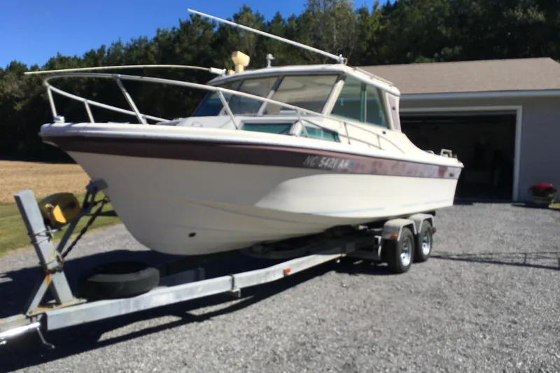 Slide: The Image of 1976 Sport-Craft 25 boat on trailer, parked outside a garage. - 11