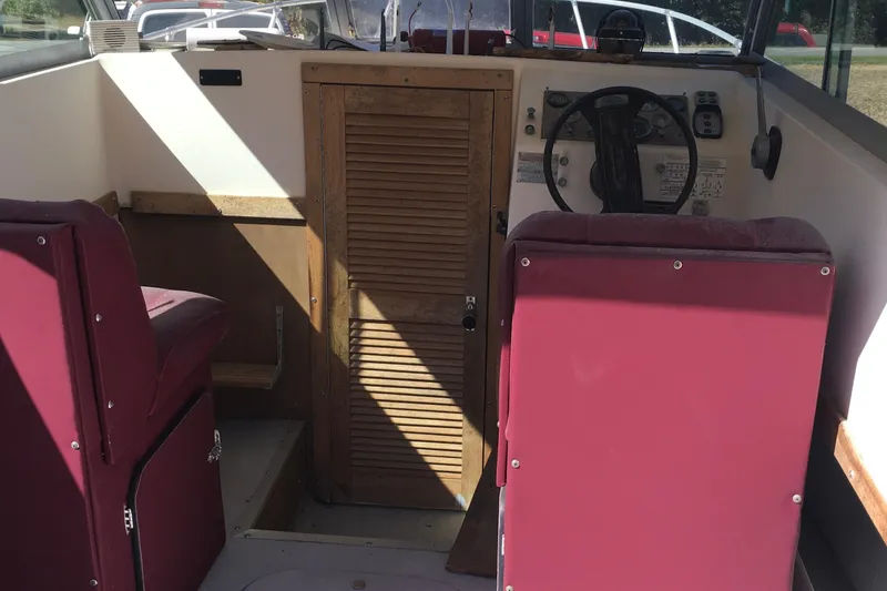 Slide: The Image of Interior of a 1976 Sport-Craft 25 boat with red seats and wooden door. - 12