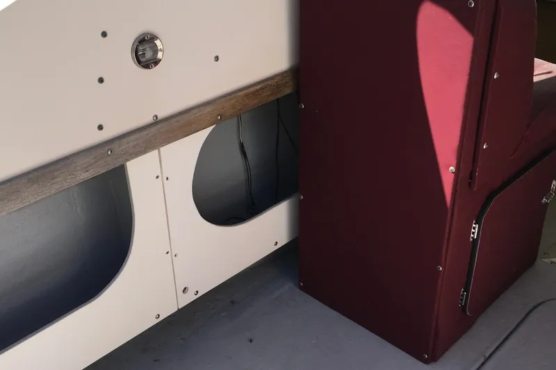 Slide: The Image of Interior view of a 1976 Sport-Craft 25 boat, featuring maroon upholstery and wooden accents. - 13