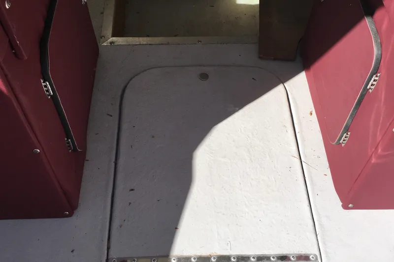 Slide: The Image of Interior of a 1976 Sport-Craft 25 boat with maroon seating and white flooring. - 15