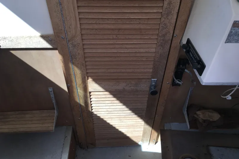 Slide: The Image of 1976 Sport-Craft 25 boat interior with wooden door and seating area. - 22