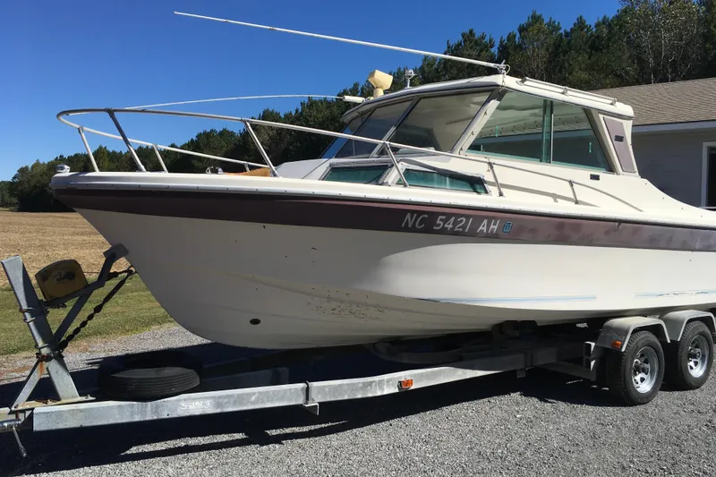 Slide: The Image of 1976 Sport-Craft 25 boat on trailer, parked outdoors under clear sky. - 6