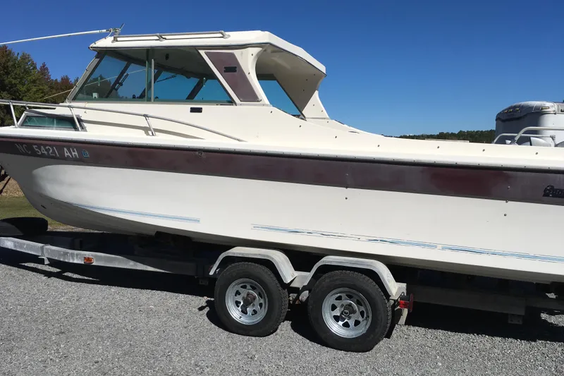 Slide: The Image of 1976 Sport-Craft 25 boat on trailer, side view, clear sky background. - 7
