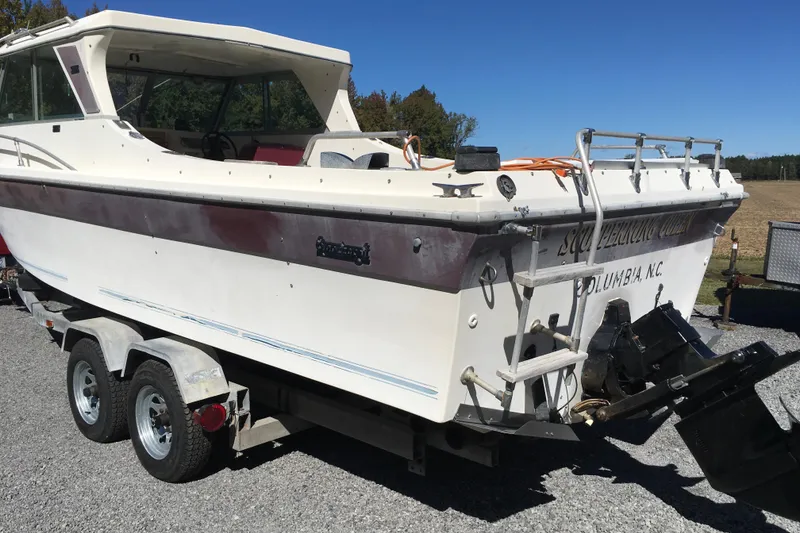 Slide: The Image of 1976 Sport-Craft 25 boat on trailer, white with maroon stripe, parked outdoors. - 8