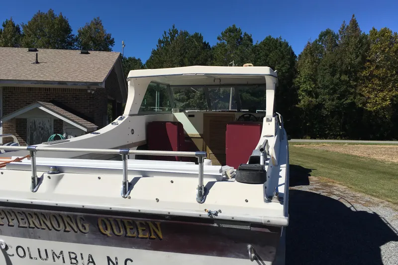 Slide: The Image of 1976 Sport-Craft 25 boat named "Scuppernong Queen" parked near a house and trees. - 9