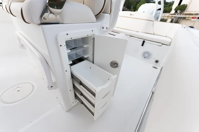 Slide: The Image of 2024 Sea Hunt Ultra 239 SE boat storage compartment with open drawers. - 19