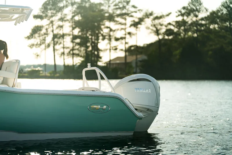 Slide: The Image of 2024 Sea Hunt Ultra 239 SE boat on calm water with Yamaha outboard motor. - 22