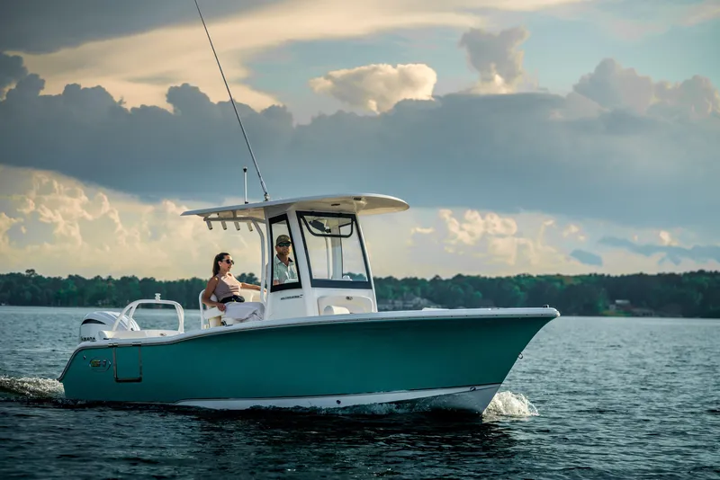 Slide: The Image of 2024 Sea Hunt Ultra 239 SE boat cruising on a lake under a cloudy sky. - 23