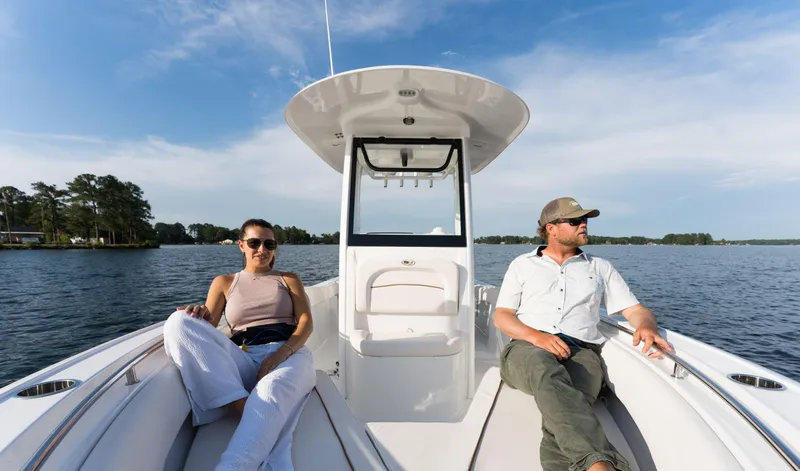Slide: The Image of 2024 Sea Hunt Ultra 239 SE boat with two people relaxing on deck. - 6