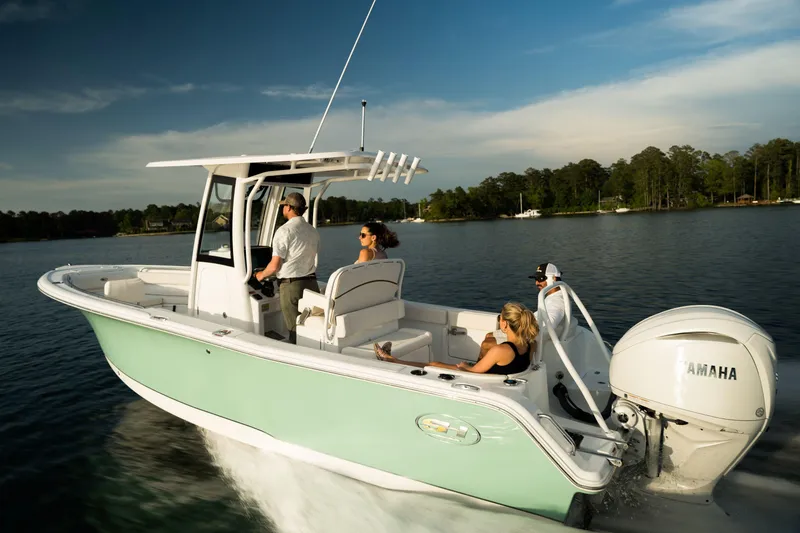 Slide: The Image of 2024 Sea Hunt Ultra 239 SE boat cruising on a lake with passengers. - 9