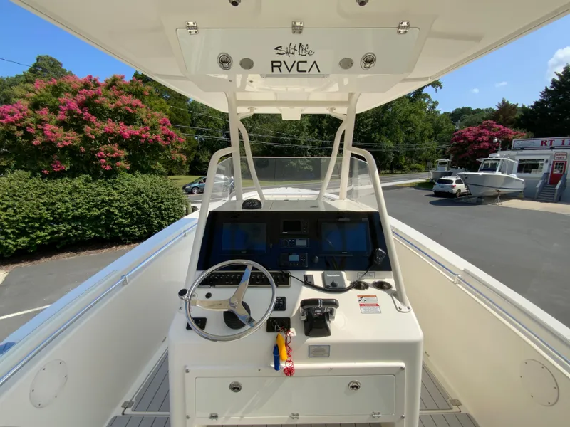 Slide: The Image of 2013 Cobia 296 Center Console boat dashboard with steering wheel and controls. - 11
