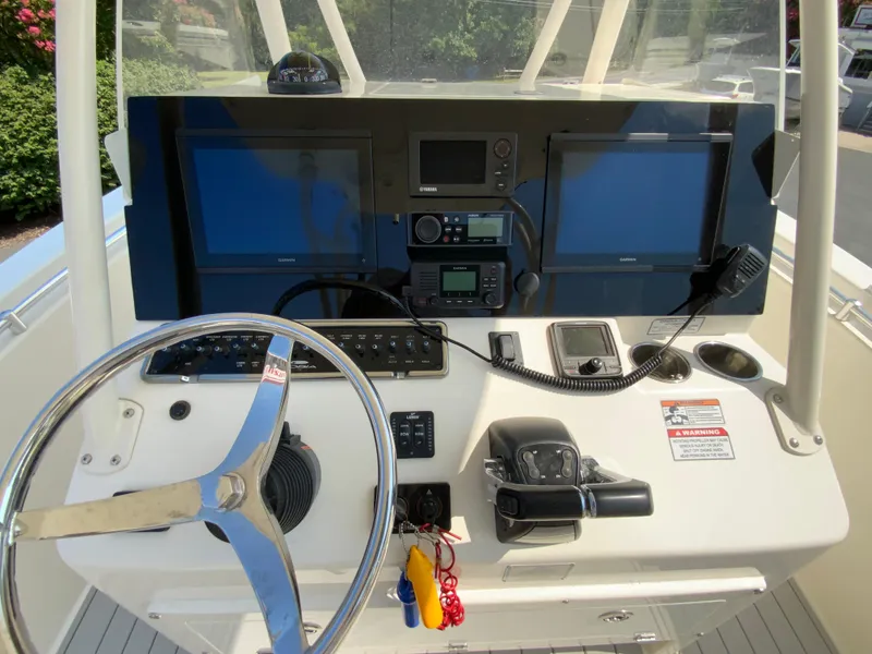 Slide: The Image of 2013 Cobia 296 Center Console helm with dual Garmin displays and steering wheel. - 12