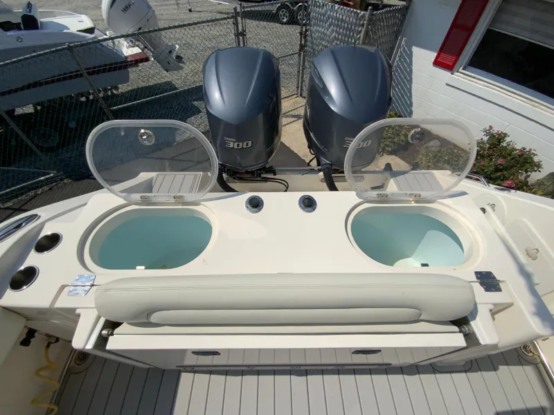Slide: The Image of 2013 Cobia 296 Center Console boat with dual Yamaha 300 engines and open livewells. - 17