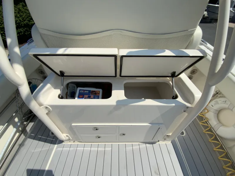 Slide: The Image of 2013 Cobia 296 Center Console boat storage compartment with open lids and visible contents. - 19