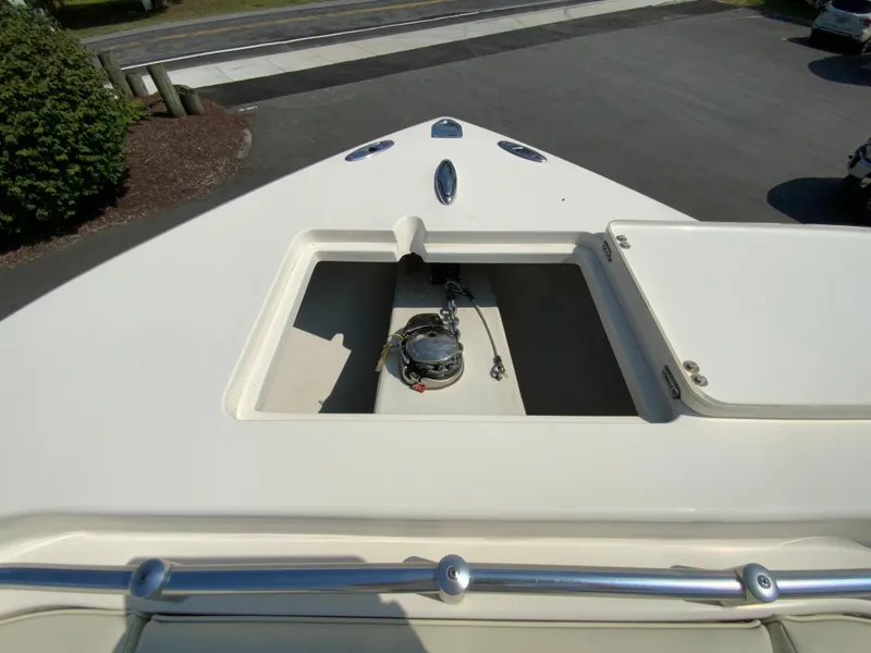 Slide: The Image of 2013 Cobia 296 Center Console boat anchor compartment, open lid, sunny day. - 25