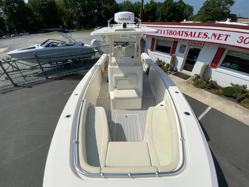 Slide: The Image of 2013 Cobia 296 Center Console boat with spacious seating, docked near a sales office. - 26