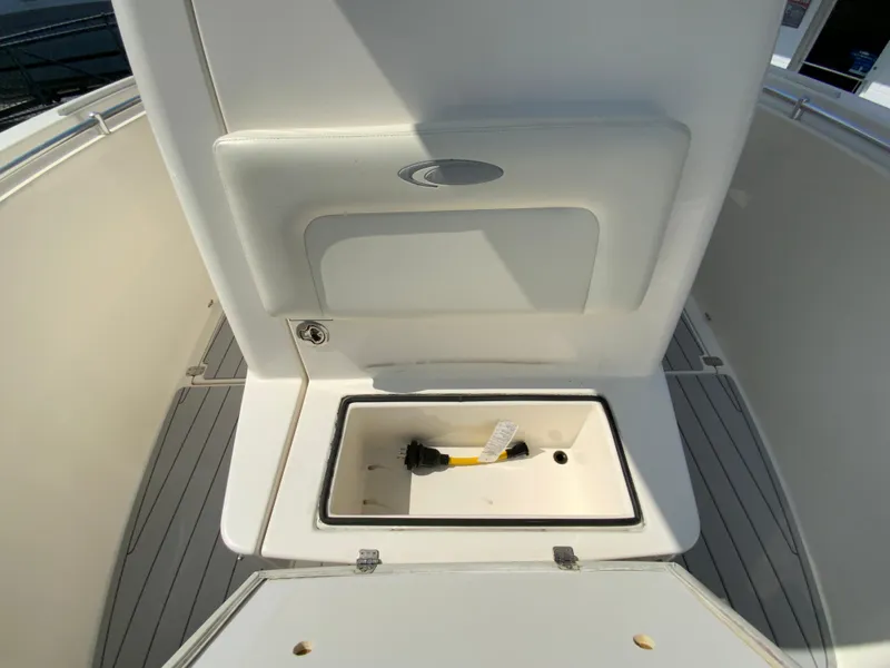 Slide: The Image of 2013 Cobia 296 Center Console boat interior storage compartment with brush. - 29