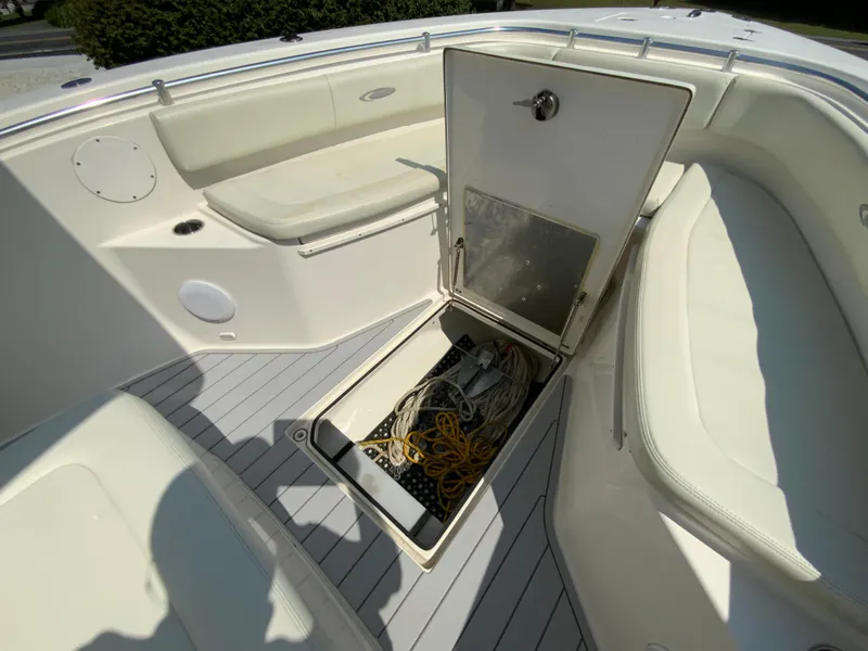 Slide: The Image of 2013 Cobia 296 Center Console boat with open storage compartment and seating area. - 30